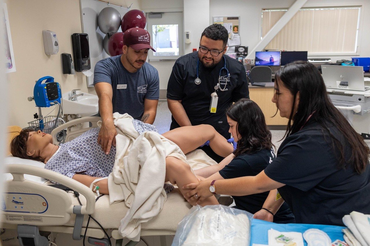 Andrew Santana (left) instructing students in performing a simulated delivery of a baby at Mt. San Antonio College campus.