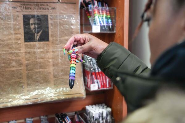 Keisha Burse looks at items for sale at Martin Luther King Jr. National Historical Park, Tuesday, Dec. 9, 2025, in Atlanta. (AP Photo/Megan Varner)