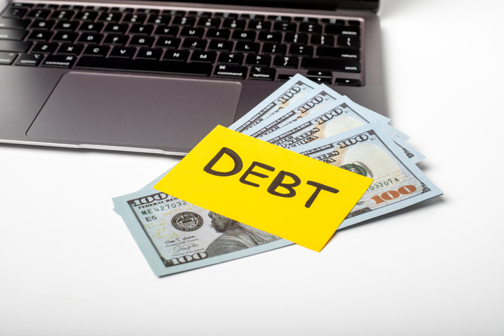 Financial debt management discussion with cash on a desk and a laptop for budgeting and planning
