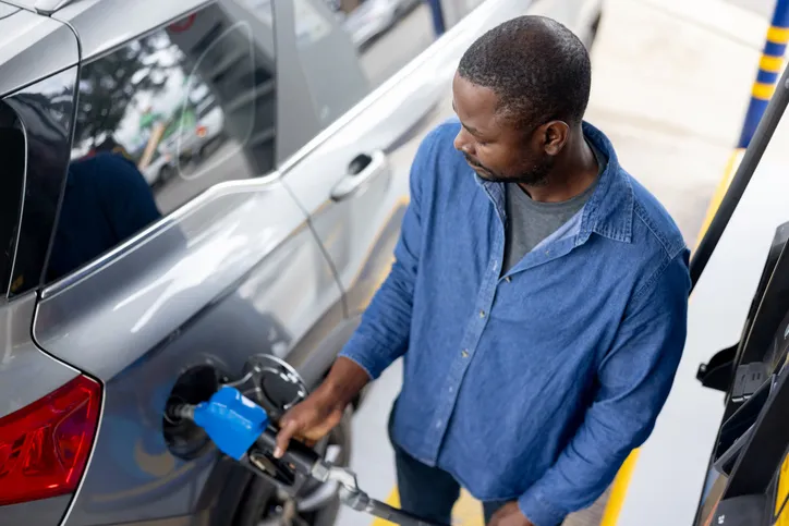Black man pumping gas | Feature Image: Why Is Gas So Expensive Right Now? 7 Things Driving Prices