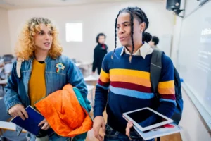 Student friends talking and leaving the classroom at university