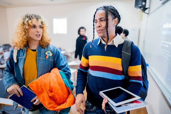 Student friends talking and leaving the classroom at university