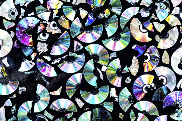Creative background made of broken CD and DVD data discs