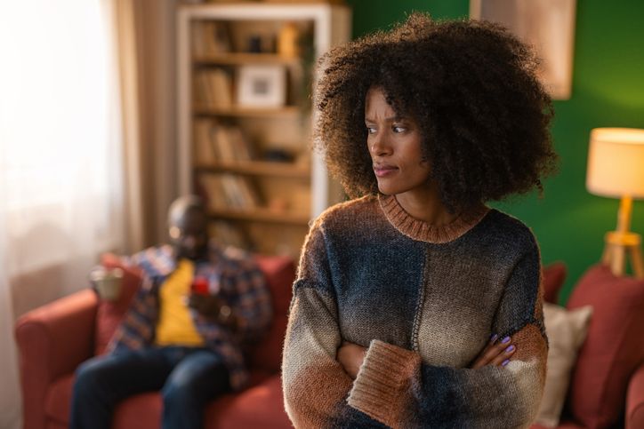 Upset woman having conflict with man in background