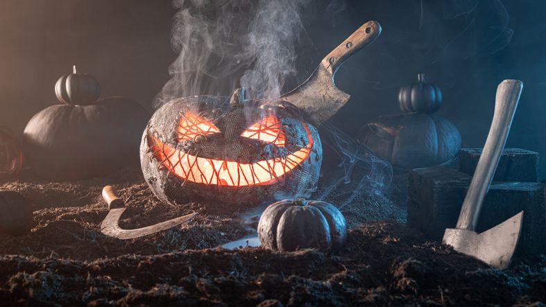 Grinning Jack-o'-lantern monster has fiery orange light inside.
